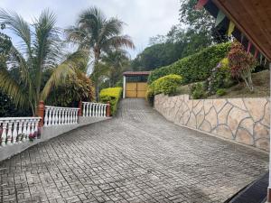a cobblestone walkway with a fence and palm trees at La mejor opción para tu descanso y recreación. in Mariquita