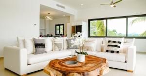 a living room with a white couch and a wooden table at La Puesta Sayulita in Sayulita