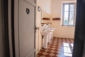 łazienka z 2 umywalkami i oknem w obiekcie Ostello di Camaiore w mieście Camaiore