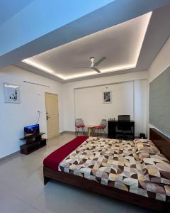 1 dormitorio con 1 cama grande y techo en Spacious Studio Penthouse, en Bangalore