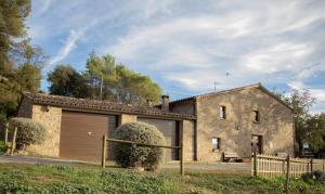 a large stone house with a garage at Mas Cal Gira in Moià