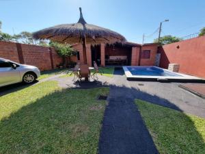 une maison avec un parasol et une piscine dans l'établissement Hospedaje Confortable en Luque, à Luque