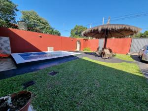 a backyard with an umbrella and a grass yard at Hospedaje Confortable en Luque in Luque