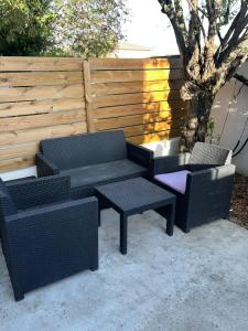 une terrasse avec deux chaises, un banc et une clôture dans l'établissement Appart toulousaine avec patio rdc, à Aucamville