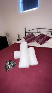 - un lit avec 2 rouleaux de serviettes dans l'établissement Appart toulousaine avec patio rdc, à Aucamville