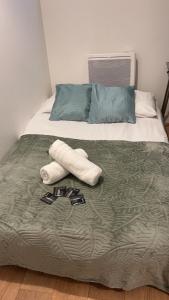 Una cama con toallas y chanclas. en Appart toulousaine avec patio rdc, en Aucamville