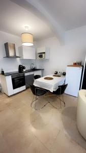 - une cuisine avec une table blanche et des chaises dans l'établissement Appart toulousaine avec patio rdc, à Aucamville