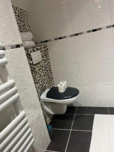 baño con aseo y asiento negro en Appart toulousaine avec patio rdc, en Aucamville