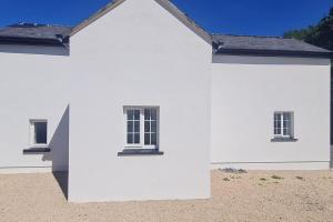 的住宿－Petit Lough Arrow cottage，白色房子的一侧有三个窗户