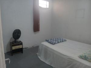 um quarto branco com uma cama e uma janela em Hostel Leonardo Quarto A em Vitória