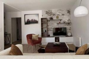 a living room with a couch and a tv at Appartement 2 chambres centre in Pessac