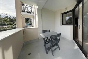 Una mesa pequeña y una silla en una habitación con ventana en Appartement 2 chambres centre, en Pessac