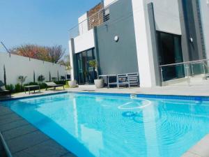 a large blue swimming pool in front of a building at Bounce Modern Home of Comfort 2 in Midrand