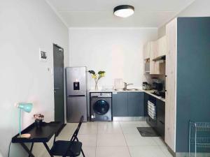 a kitchen with a refrigerator and a table and chairs at Bounce Modern Home of Comfort 2 in Midrand