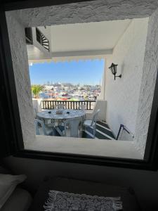 a room with a table and a balcony with a view at Appartement maria marina in Sousse