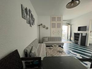 a living room with a couch and a table at Appartement maria marina in Sousse