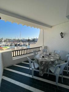 a table and chairs on a balcony with a marina at Appartement maria marina in Sousse