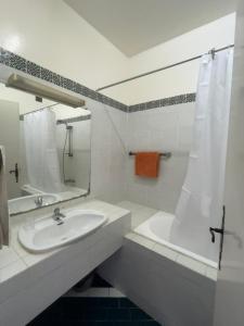 a bathroom with a sink and a tub and a mirror at Appartement maria marina in Sousse