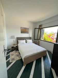 a bedroom with a large bed and a window at Appartement maria marina in Sousse