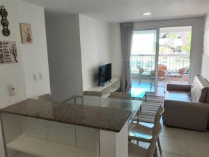 a kitchen and living room with a glass counter top at Apartamento Porto Beach Residence in Aquiraz