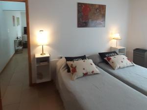 1 dormitorio con 2 camas individuales y lámpara en Sterlizia departamento en Olavarría