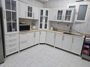 a white kitchen with white cabinets and appliances at شقة فاخرة لاقامة مثالية in Jazan