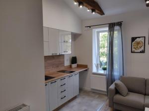 una cocina con armarios blancos y una ventana en Konopnickiej 9 Loft z antresolą, en Pabianice