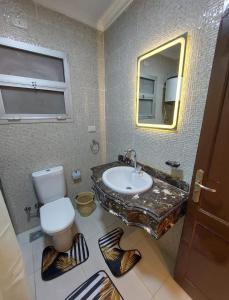 y baño con lavabo, aseo y espejo. en Gazzar inn rehab9, en El Cairo