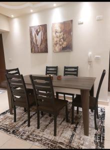 uma sala de jantar com uma mesa de madeira e cadeiras em Gazzar inn rehab9 no Cairo