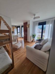 a living room with a white couch and a staircase at La Casina Del Alce in Aller