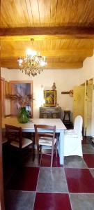 una sala da pranzo con tavolo, sedie e lampadario pendente di La Stella a Civita
