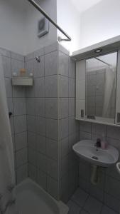 a white bathroom with a sink and a mirror at Savska - Apartment in Sajmište