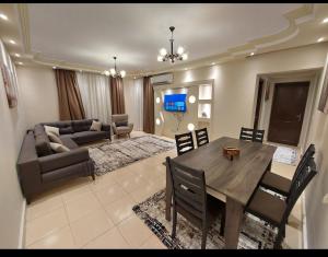 sala de estar con mesa y sofá en Gazzar inn rehab9, en El Cairo