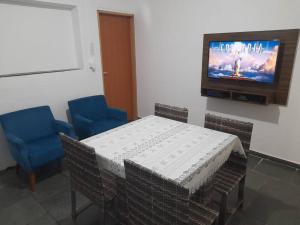 a room with a table and two chairs and a television at Casa com 3 quartos in Itu