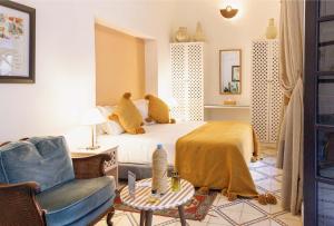 a bedroom with a bed and a chair and a table at Riad Zouhour in Marrakesh