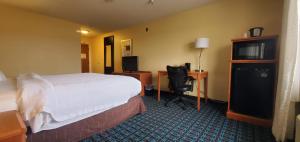 Habitación de hotel con cama, escritorio y silla en Quail Springs Inn & Suites, en Oklahoma City