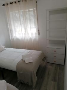 een slaapkamer met een bed en een dressoir met twee handdoeken erop bij Baleal Atlantic 6 in Baleal
