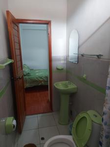 uma casa de banho com um WC verde e um lavatório em Mirador de Cumbaza House em Tarapoto