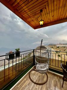 una sedia su un balcone con vista sull'oceano di فندق كوخ الضباب النماص a Al Namas
