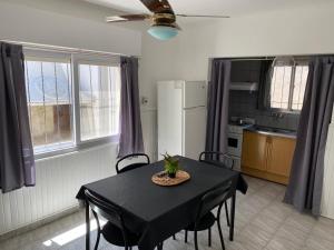 a kitchen with a black table and chairs in a room at Alem Departamento Tornquist in Tornquist