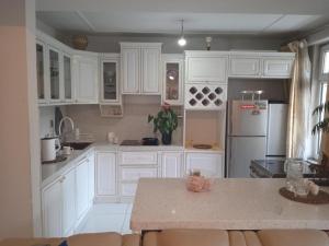 a kitchen with white cabinets and a white refrigerator at Bolod Guesthouse and Tours in Ulaanbaatar