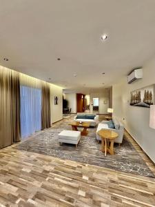 un soggiorno con divani e tavoli in una stanza di فندق كوخ الضباب النماص a Al Namas