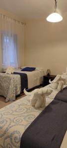 ein Schlafzimmer mit 2 Betten und einem Elefanten auf dem Boden in der Unterkunft Pensión Mar in Portomarin