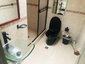 聖羅莎德卡瓦爾的住宿－Casa rural o chalet，浴室设有黑色的卫生间和玻璃水槽。