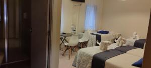 Zimmer mit 3 Betten, Tisch und Stühlen in der Unterkunft Pensión Mar in Portomarin
