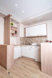 a kitchen with white cabinets and a wooden floor at Apartman Jula 122 in Zlatibor