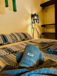 a bed with pillows on it in a room at Residencial Bem-te-vi in Jericoacoara