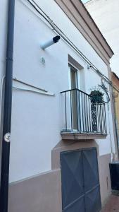 Casa bianca con porta blu e balcone di La Casetta a Ordona