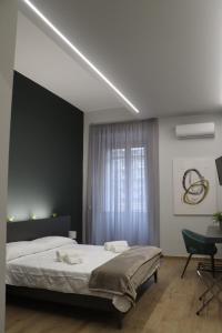 una camera con un grande letto e una scrivania di IOLETTA HOUSE a Catania