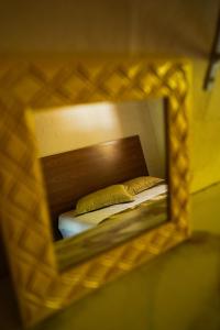 Chalé Vista da Pedra في جونسالفيس: مرآة تعكس سرير في غرفة النوم